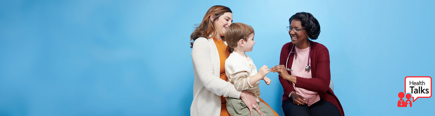 A pediatrician talking to a parent and patient